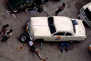 Americans John Jung and Andy Vann work on their 1950 
Ford Club coupe.