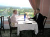 Nancy and Ken in formal dining room with views of mountains, tennis courts outside